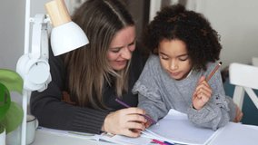 Caucasian mother and African American daughter studying at home, doing homework in cosy white room. Parent teach, child school girl learn knowledge, write exercise read book. Education for children - Powered by Shutterstock - Get 15% off with code: PIKWIZARD15