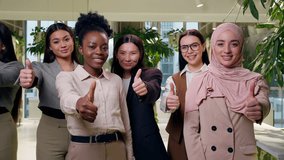 Positive joyful multiethnic women females diverse five girls coworkers businesswomen business looking camera showing thumb up gesture raise finger approval recommend reaction like good indoors office - Powered by Shutterstock - Get 15% off with code: PIKWIZARD15