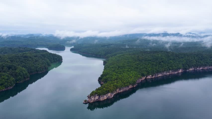 High above Summersville, West Virginia, the aerial view of Summersville Lake reveals its expansive beauty, bordered by green hills and rocky cliffs.
