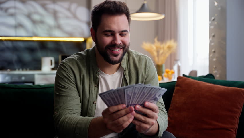 Happy rich wealthy Caucasian business man male guy businessman homeowner client looking camera waving fan money stack cash dollars banknotes finance income wealth win lottery prize profit indoors home