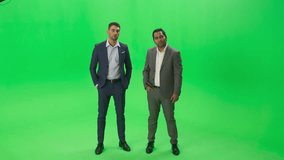 Green Screen Chroma Key Background: Two Businessmen, Wearing Modern Suits, Stand Talking, Professional Meeting Setting. Gesture Confidently, Corporate Marketing, Commercian Business Entrepreneurship - Powered by Shutterstock - Get 15% off with code: PIKWIZARD15