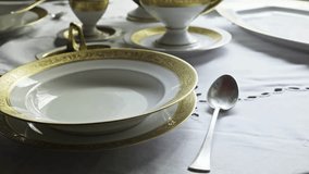 Waiter Sets formal banquet table with Gilded Chinaware and silverware - Powered by Shutterstock - Get 15% off with code: PIKWIZARD15