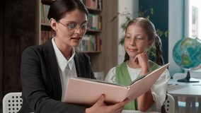 Kind adult Caucasian teacher professor woman female tutor reading story book storytelling explaining little girl school child student kid learner schoolgirl pupil listen task indoors classroom lesson - Powered by Shutterstock - Get 15% off with code: PIKWIZARD15