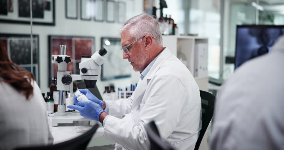 Mature scientist, man and team with sample at lab for problem solving with medical research, dna or vaccine trial. People, group and leader with container, chemical solution and pharmaceutical study