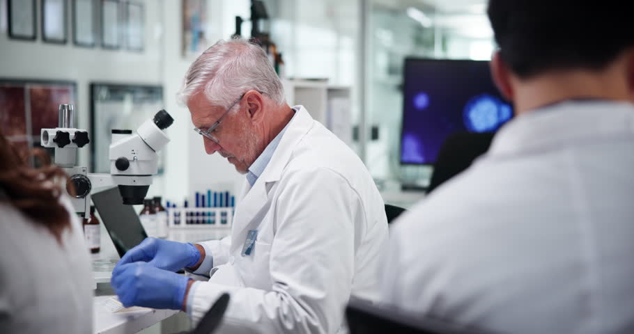 Mature scientist, man and team with sample at lab for problem solving with medical research, dna or vaccine trial. People, group and leader with container, chemical solution and pharmaceutical study