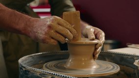 Close up smiling happy focused Caucasian man guy small business owner businessman crock potter male making pottery ceramic shaping wet clay rotating wheel looking at camera wave hand indoors workshop - Powered by Shutterstock - Get 15% off with code: PIKWIZARD15