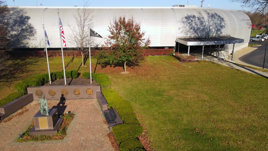 Veterans memorial plaza with flag display and civic building in Flat Rock