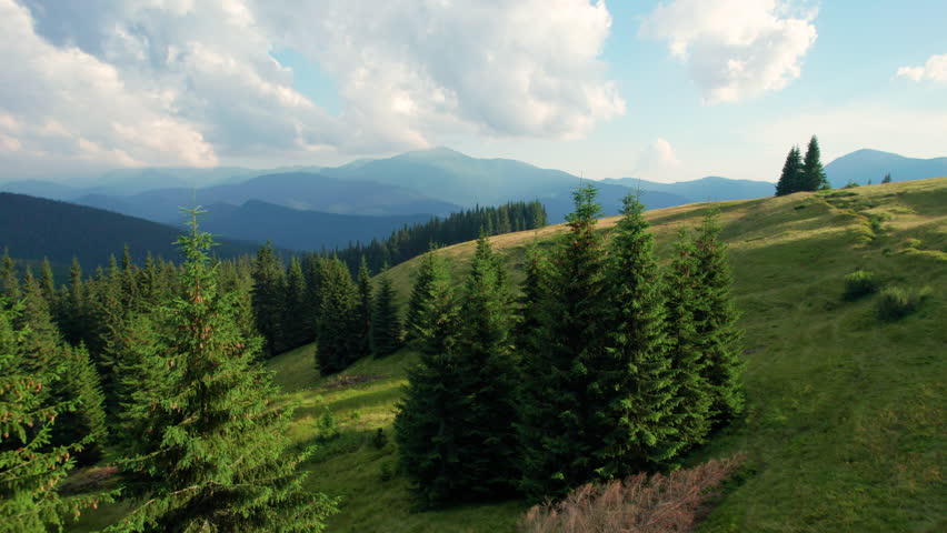 Aerial view of tranquil twilight scene over rolling hills and lush forests. Peaceful and picturesque view of nature.