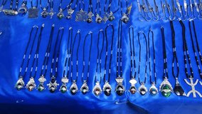 Beautiful traditional Tuareg and Berber amulets and jewelry displayed on a blue cloth at a local market in Djanet, in the Saharan desert region of Algeria - Powered by Shutterstock - Get 15% off with code: PIKWIZARD15