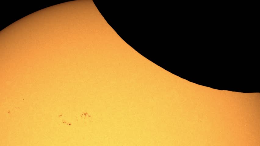 Partial solar eclipse close-up with visible Moon montains