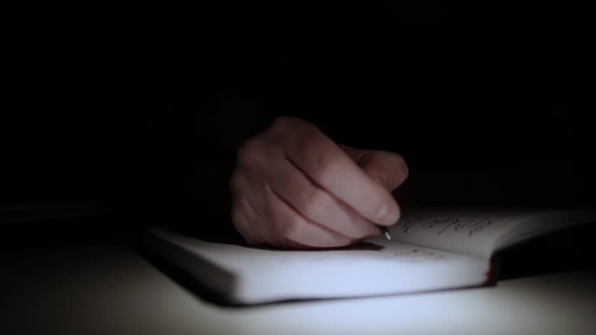 man journaling his thoughts into notebook, because he has some sort of depression, problems and want to find out and help himself without psychologist