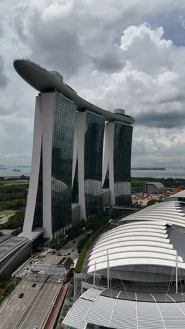 Vertical, aerial: Marina Bay Sands during the day with river in the Central Region of Singapore, pull out drone shot