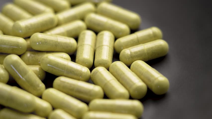 Immune support quercetin capsules with bromelain extract in a ceramic bowl. Supplement pills. Macro. Rotation
