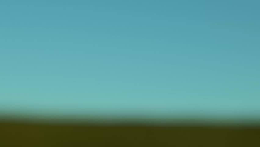 A lonely guy rides a bike on a green hill, under a clear blue sky. Serene and minimalist, it evokes freedom, making it perfect for themes of nature, travel, and lifestyle.