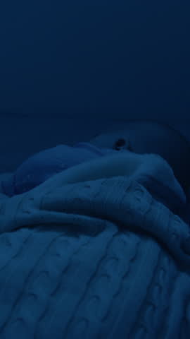 Image at night through the darkness baby sleeps healthy and peacefully alone in his comfortable crib. Child sleeps sweetly and aims in peace, safety and love. Maternity, newborns
