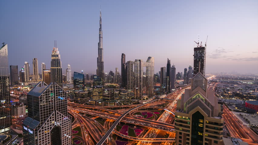 Day to night timelapse of modern buildings and traffic on major interchange in Downtown Dubai, United Arab Emirates (UAE).	