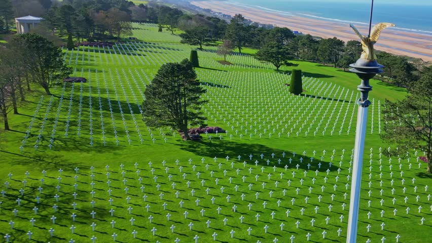 Amazing upward drone movement at the famous Normandy American Cemetery with rows of white memorial military crosses, Colleville-sur-Mer, Omaha Beach, France.