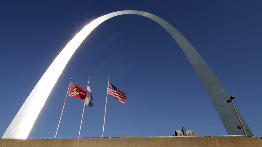 Gateway Arch in the city of St Louis, USA, with flags waving.