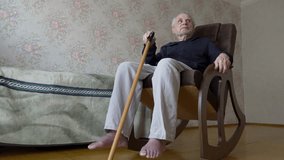 Senior man sitting in a rocking chair, holding a walking stick for support. Theme of aging, mobility, and elder care - Powered by Shutterstock - Get 15% off with code: PIKWIZARD15