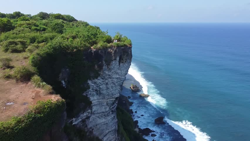 Aerial Flyover of People on Uluwatu Island Cliff Edge in Bali