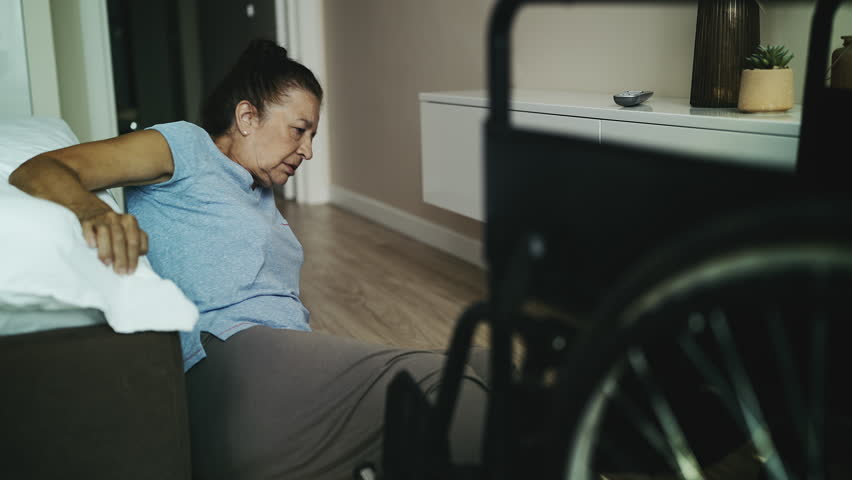 Helpless senior woman with reduced mobility trying to stand up after falling