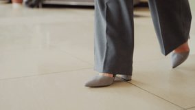 Close-up of businesswoman's feet in gray heels walking confidently across polished office floor, emphasizing motion, elegance, and professionalism in corporate setting - Powered by Shutterstock - Get 15% off with code: PIKWIZARD15