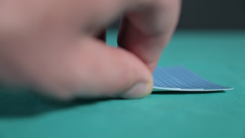 Watch as a lucky poker player lifts their cards, revealing four aces in an incredible hand. The green felt table sets the stage for this dramatic moment in high-stakes poker