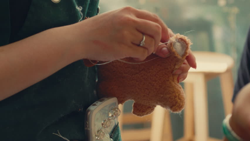 Hands Stitching a DIY Bear at Build-A-Bear Workshop - Close Up