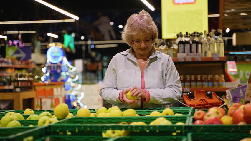 Senior Woman Selecting Fresh Apples at Grocery Store