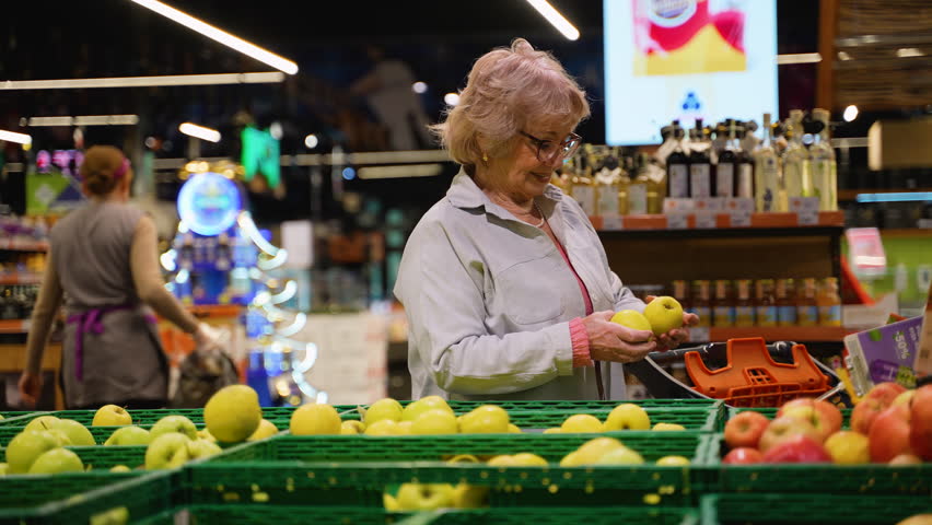 Senior Woman Selecting Fresh Apples at Grocery Store