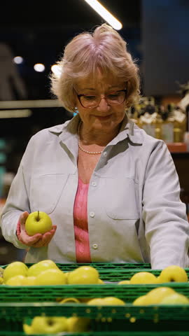 Senior Woman Selecting Fresh Apples at Grocery Store
