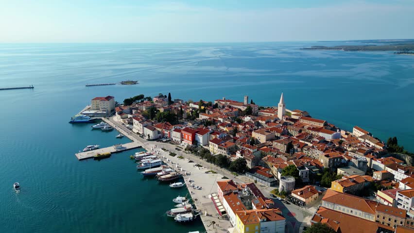 Aerial view of Poreč (Porec), Croatia, showcasing the charming old town, vibrant coastline, and the nearby island of Sveti Nikola. The stunning Zelena Laguna area adds to the beauty turquoise waters