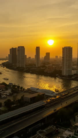 Aerial view Bangkok City skyline and skyscraper in Bangkok downtown, Taksin Bridge over Chao Phraya River at sunset, Bangkok, Thailand. Vertical video 4k