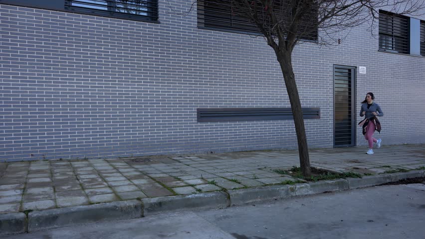 Female runner tracking her pulse on smartwatch during city run