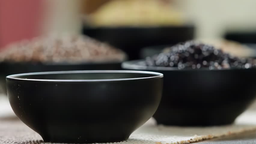 A variety of different colored Raw healthy grain food, Various grains, cereals, beans, legumes are rotated in wooden decoration for advertisement concept. High protein products, Healthy vegan food.