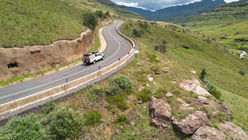 Winding mountain road of South Africa, SUV driving upward, aerial view