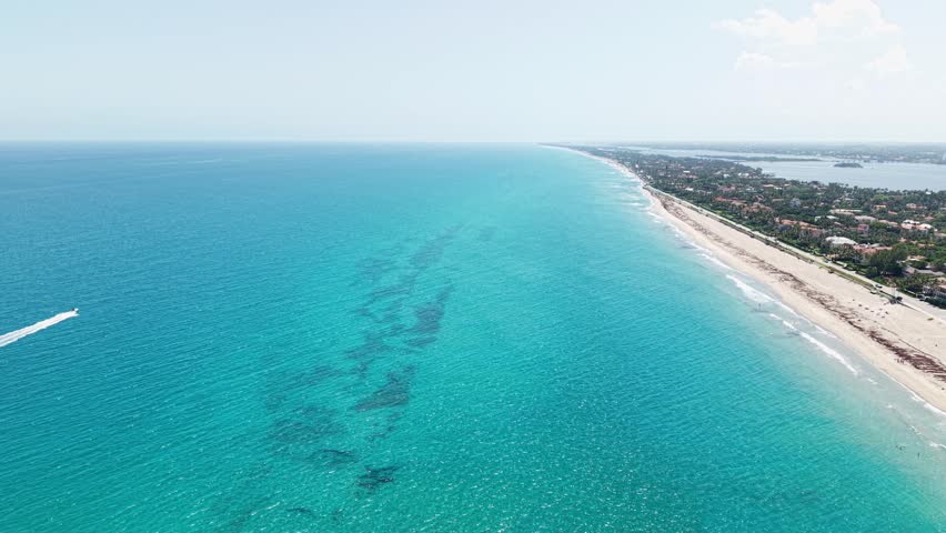 Push in drone shot of turquoise water of Atlantic Ocean near Municipal Beach during the day in West Palm Beach, Florida, USA