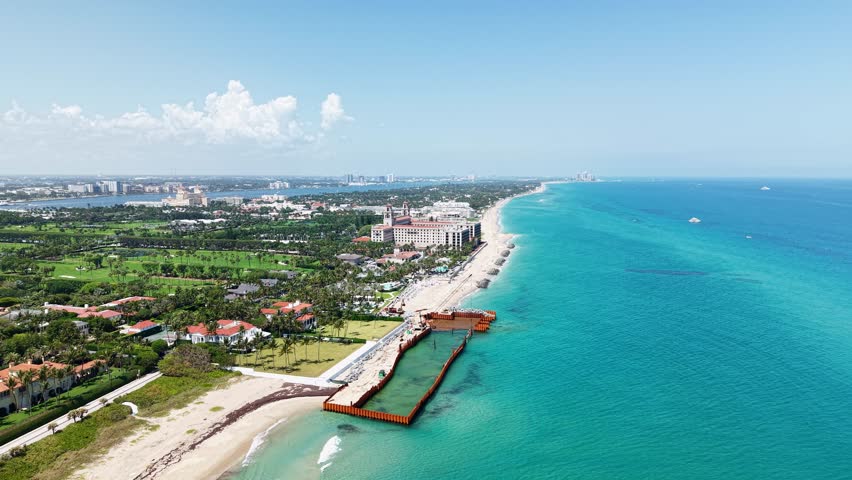 Aerial: Municipal Beach next to Atlantic Ocean with hotels and sand beach during the day in West Palm Beach, Florida, USA, establishing drone shot