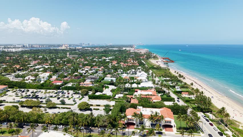 Establishing drone shot of Municipal Beach and Atlantic Ocean with homes and sand beach during the day in West Palm Beach, Florida, USA