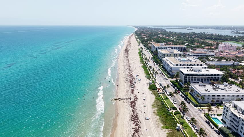 Aerial: Municipal Beach and Atlantic Ocean with hotels and sand beach during the day in West Palm Beach, Florida, USA, establishing drone shot