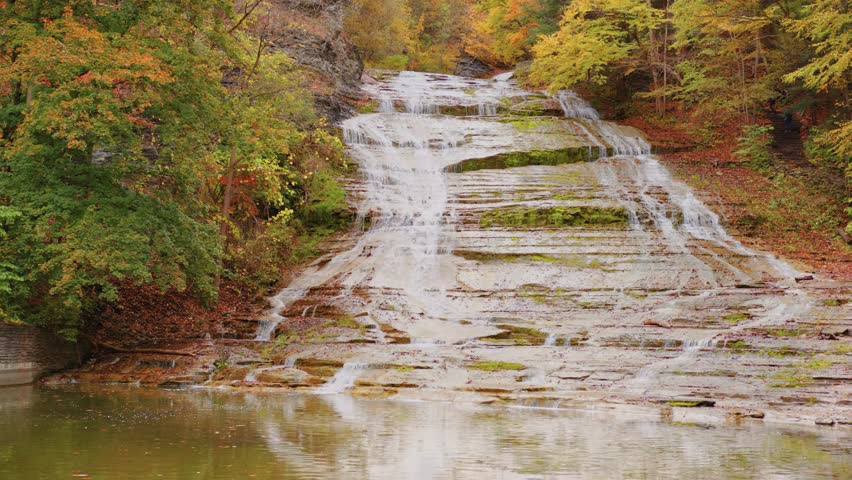 This 4K footage features Buttermilk Falls waterfall flowing gracefully among autumn foliage in Ithaca, NY—perfectly capturing fall serenity and seasonal natural beauty