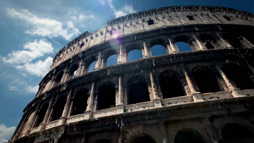 Colosseum stands majestically in ancient Rome, showcasing its architectural grandeur. Visitors stroll around its iconic structure, soaked in warm sunlight and surrounded by historical ambiance.