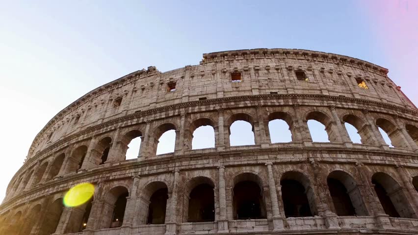 Majestic silhouette of Colosseum against clear evening sky showcases ancient architecture. Visitors marvel at this iconic structure in Rome, Italy, experiencing rich history.