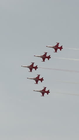 Vertical video. The Turkish Stars aerobatic team performs at the beach in Antalya, flying in a tight formation.