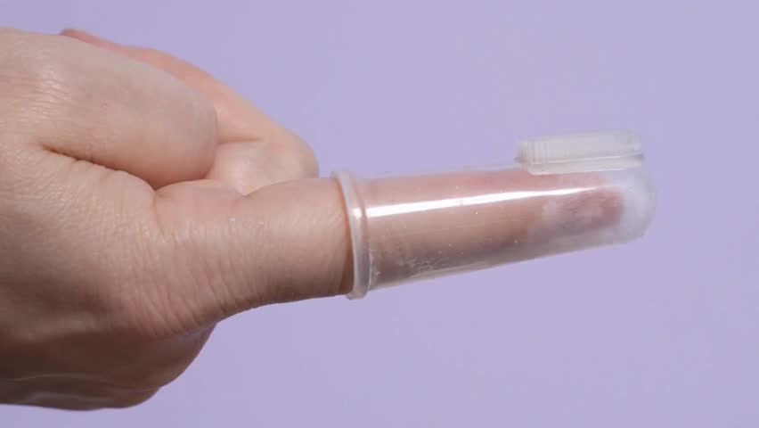 close-up squeezes the white toothpaste onto the tiny head toothbrush for pets dog or cat against Angle macro shot of toothpaste prevent tooth decay