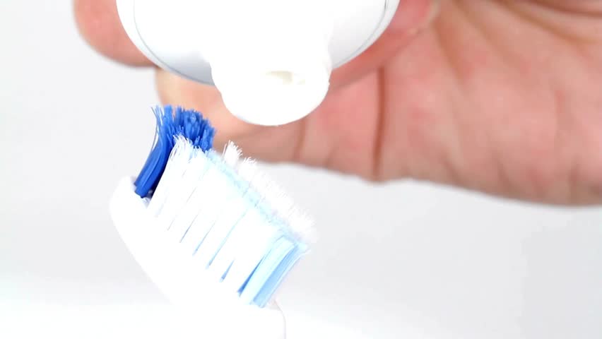 healthcare, Close up shot of toothpaste being put on toothbrush. modern toothbrush handle and bristles with activated paste fluoride active carbon
