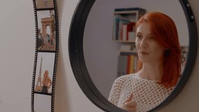 Cheerful redhead practices her presentation in front of a mirror at home. She expresses confidence and prepares for her upcoming speaking engagement. - Powered by Shutterstock - Get 15% off with code: PIKWIZARD15