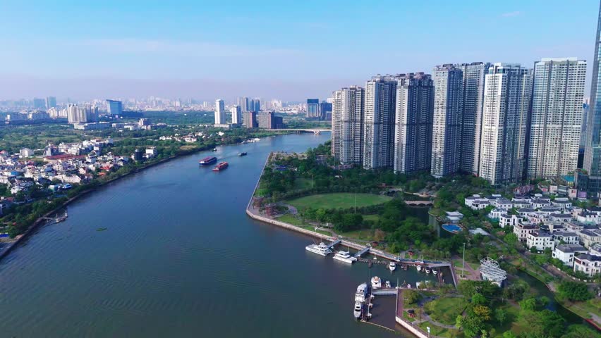 An aerial view of the Vinhomes Central Park with the urban buildings overlooking Saigon River on a sunny day in Binh Thanh, Ho Chi Minh City, Vietnam