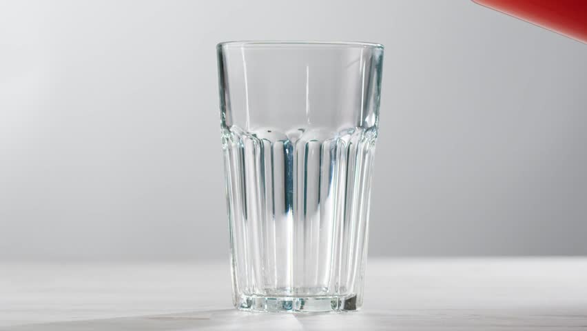 Woman pouring grapefruit juice from juicer into glass on colorful background, citrus vitamic c healthy fresh juice in cafe, morning breakfast drink.