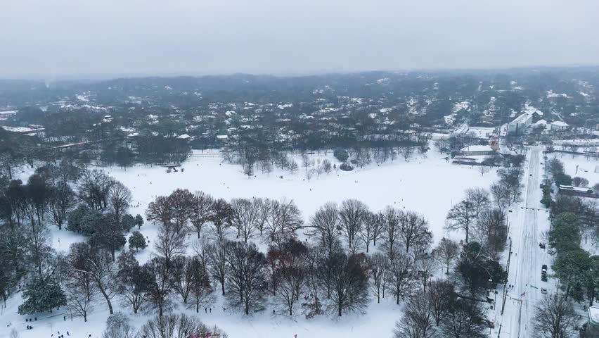 Aerial push in on a snow covered Piedmont Park in Atlanta, Georgia on January 10th 2025.